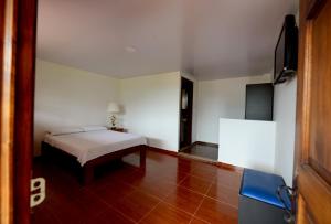 a bedroom with a bed and a chair in it at Hostal Origen Colonial in Salento