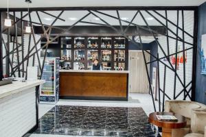 a bar with a woman behind the counter at Express City Hotel in Shymkent