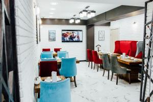 a restaurant with tables and chairs in a room at Express City Hotel in Shymkent