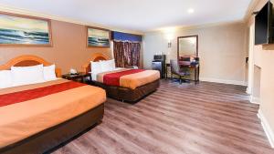 Cette chambre comprend deux lits et un bureau. dans l'établissement Pacifica Motel, à Long Beach