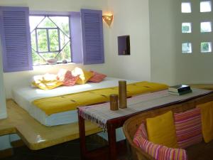 a bedroom with a bed with a window and a table at Amaranto Bed and Breakfast in Cozumel