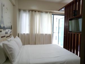 a bedroom with a white bed and a window at NEW CONDO UNIT@PALMTREE VILLAS NEAR NAIA3 in Manila