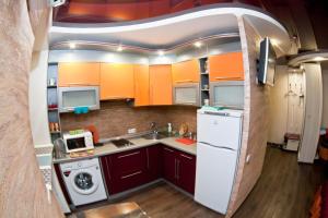a kitchen with orange cabinets and a white refrigerator at затишна квартирка in Kremenchuk