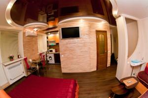 a living room with a red couch and a tv at затишна квартирка in Kremenchuk