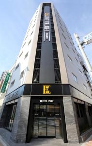 un edificio alto con un cartel de hotel en Hotel Emit Ueno, en Tokio