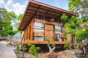 a small wooden house with a porch at Tevana House Reef in Bira