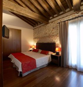 sypialnia z dużym łóżkiem i czerwonym kocem w obiekcie El Pontifical w mieście Los Santos de la Humosa