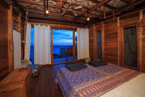 a bedroom with a bed and a view of the ocean at Tevana House Reef in Bira