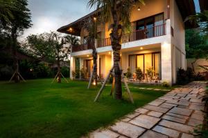 a house with a lawn in front of it at Villa Puri Ayu in Sanur