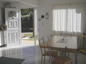 a dining room with a table and chairs and a door at Complejo Marce in Ostende