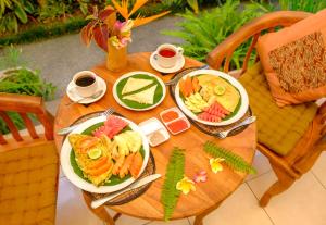 une table en bois avec deux assiettes de nourriture dans l'établissement Semujan Bungalow, à Ubud