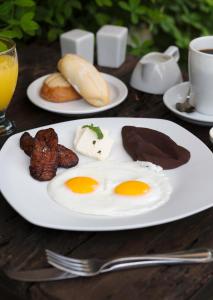 a plate of eggs and other food on a table at Los Olivos Boutique Hotel Antigua Guatemala in Antigua Guatemala