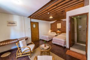 a bedroom with two beds and a table and chairs at Kantipur Temple House in Kathmandu