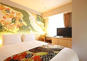金沢市にあるホテルウィングインターナショナルプレミアム金沢駅前のベッドとテレビ付きのホテルルーム