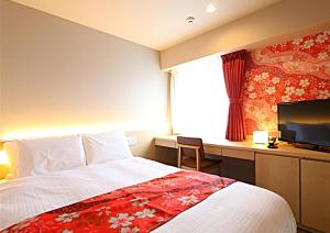 una camera d'albergo con letto e TV di Hotel Wing International Premium Kanazawa Ekimae a Kanazawa