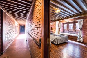 a bedroom with a bed in a brick wall at Kantipur Temple House in Kathmandu