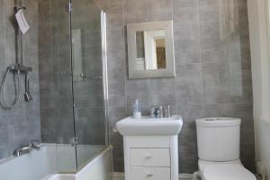 a bathroom with a shower and a toilet and a sink at The Wimbledon Hotel in London