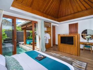 a bedroom with a bed and a tv and a pool at S18 Bali Villas in Legian