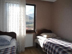 una camera da letto con due letti e una finestra di Guest House Sunset a Kazbegi