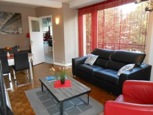 a living room with a black couch and a table at Gite Clemenceau in Rouen