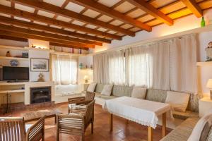 Villa Bonaire في الكوذيا: غرفة معيشة مع أريكة وطاولة وكراسي