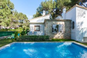 a house with a swimming pool in front of a house at Villa Bonaire in Alcudia