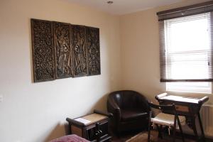 a room with a chair and a desk and a window at The Wimbledon Hotel in London