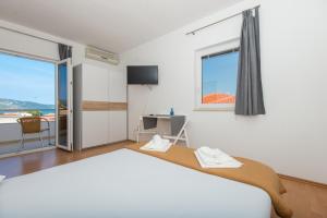 een slaapkamer met een groot bed en een raam bij Apartments Kairos in Seget Vranjica