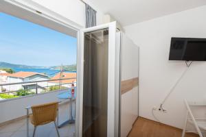 um quarto com uma varanda com vista para o oceano em Apartments Kairos em Seget Vranjica