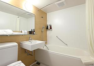 y baño con lavabo, bañera y espejo. en Hotel Wing International Premium Kanazawa Ekimae, en Kanazawa