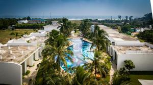 an aerial view of a resort swimming pool with palm trees at Grande Bay Resort and Spa Mamallapuram in Mahabalipuram