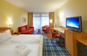 a hotel room with a bed and a flat screen tv at Göbel's Seehotel Diemelsee in Diemelsee