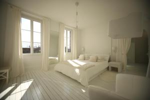 a white bedroom with a bed and a window at Les Rêves de Flamboin in Gouaix