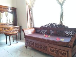 una gran cama de madera con flores en una habitación en Nuriani Guest House en Ubud