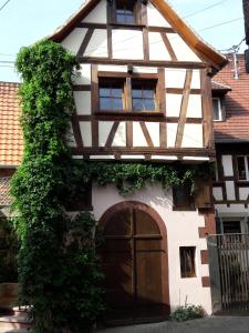 ein Haus mit einer großen Holztür und Efeu in der Unterkunft Comme une tour dans le centre Historique in Bouxwiller