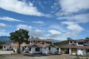 grupa białych domów z niebieskim niebem w obiekcie Sierra Alisos Hotel de Campo w mieście Hacienda Tambillo Alto