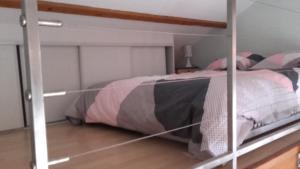 a bedroom with a bunk bed with pink and gray sheets at Studio meublé in Lumes