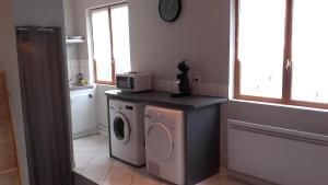 a kitchen with a washing machine and a microwave at Studio meublé in Lumes