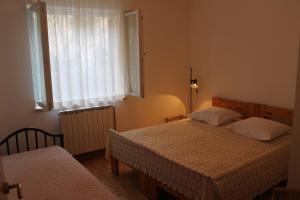 a bedroom with two beds and a window at Apartments Vila Marica in Rabac