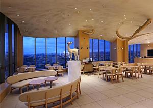 un ristorante con tavoli e sedie e un dinosauro sul soffitto di Hotel Wing International Premium Kanazawa Ekimae a Kanazawa