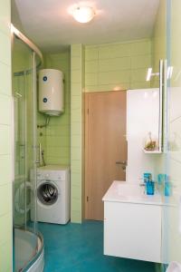 a bathroom with a washing machine and a washer at Apartments Sky in Šibenik