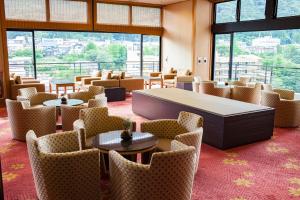 Pokój z krzesłami, stołem, stołami i krzesłami w obiekcie Kinugawa Onsen Sanraku w mieście Nikko