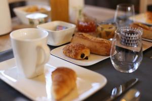 - une table avec des assiettes de pâtisseries et une tasse de café dans l'établissement Les Rêves de Flamboin, à Gouaix