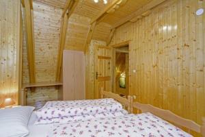 1 dormitorio con 1 cama en una pared de madera en Chalets Bogo & Neno en Ledenice