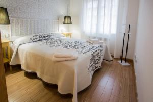 Un dormitorio con una cama blanca con toallas. en Apartamentos Abula, en Ávila