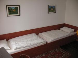two beds sitting in a room with two pictures on the wall at Pension Hinz & Kunz in Weimar
