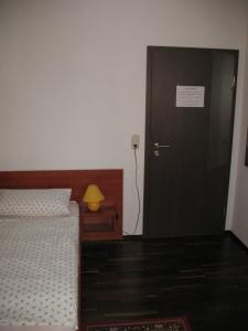 Dormitorio con puerta, cama y lámpara en Pension Hinz & Kunz, en Weimar