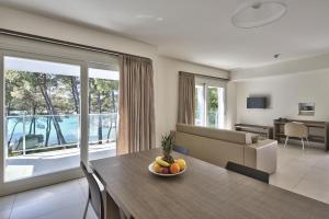 a living room with a table with a bowl of fruit on it at Crvena Luka Resort in Biograd na Moru
