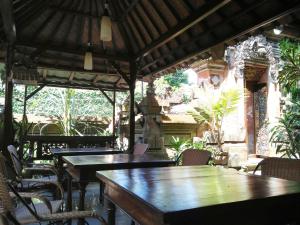 a patio with tables and chairs in a restaurant at Nuriani Guest House in Ubud