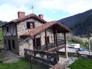 a small stone house with a wooden porch at Apartamentos Casa Placida 1 in Frama